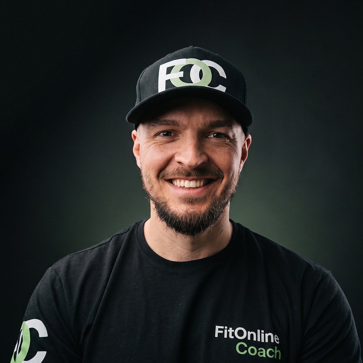 Tomek Wiesner, trener personalny FitOnlineCoach, w czapce i koszulce z logo FOC